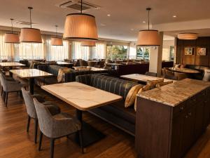 a restaurant with couches and tables and chairs at Mercure Clear Mountain Lodge in Mount Samson