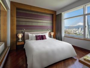 a bedroom with a large white bed and a window at Grand Mercure Danang - 10 minutes to Airport & 200m to Bach Dang Walking street in Danang