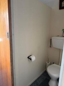 a bathroom with a toilet and a toilet paper roll at Lime Ridge Farm Cottage in Fairlie +9 photos
