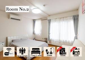 ein Zimmer mit einem Bett und einigen Aufklebern darauf in der Unterkunft まち宿門 in Nakatsugawa