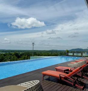 a large swimming pool with lounge chairs at wyndham panbil sanctuary in Kangboi