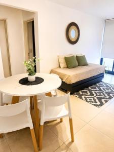 a living room with a table and a bed at LA RIVIERA María II - CON COCHERA in Villa María