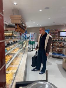 a man is standing in a bakery aisle at Add Hotéis Mascote in São Paulo