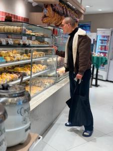 a man is looking at pastries in a bakery at Add Hotéis Mascote in São Paulo