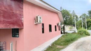a pink building with windows on the side of it at Roomstay Ust Omar in Tumpat