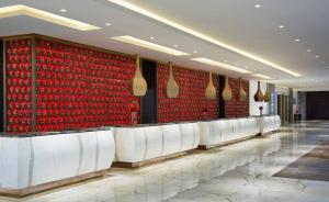 a row of seats in a lobby with red wall at Gran Meliá Xian in Xi'an