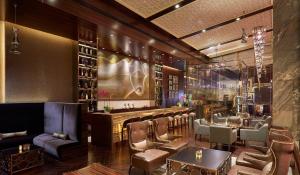 a restaurant with a bar with chairs and tables at Gran Meliá Xian in Xi'an