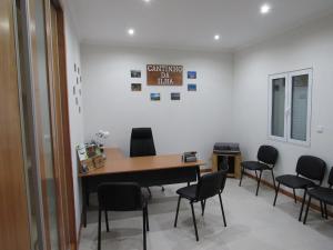 ein Wartezimmer mit Tisch und Stühlen in der Unterkunft Cantinho da Ilha in Achadinha