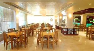 a restaurant with wooden tables and chairs in a room at Au Lac 2 Hotel in Ho Chi Minh City