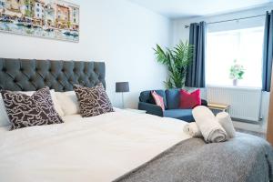 a bedroom with a large white bed and a blue chair at Charles House in Chatham