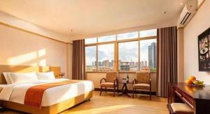 a hotel room with a bed and a large window at Cheerful Hotel in Nanhai +289 photos
