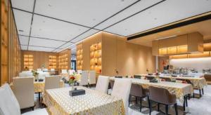 a dining room with tables and chairs in a restaurant at Oriental Glory Hotel in Dongguan