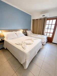 a hotel room with two beds and a window at Pousada La Riviera - Pé na areia e Passeios em Maragogi in Maragogi +80 photos