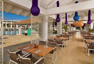a restaurant with wooden tables and purple lights at Paradisus by Meliá Grand Cana - All Suites - All Inclusive in Punta Cana