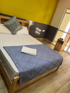 a bedroom with a bed with a towel on it at Gelephu city hotel in Geylegphug