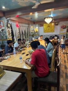 a group of people sitting at a table in a restaurant at Gelephu city hotel in Geylegphug