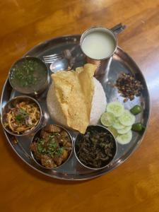a tray with a plate of food and a glass of milk at Gelephu city hotel in Geylegphug