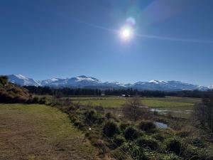 a view of the mountains from a field at Lime Ridge Farm Cottage in Fairlie