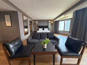 a living room with a couch and a bed at Marine Plaza Hotel Pattaya in Pattaya South
