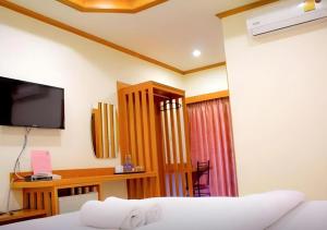 a hotel room with a bed and a television at Loei Residence in Ban Tha Phae