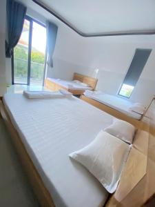 a bedroom with two beds and a window at Nhà Nghỉ THÀNH LỘC in Long Hai +31 photos