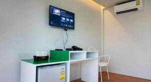 a room with a desk and a tv on the wall at Baan Kula Mahasarakam in Ban Nong Chik