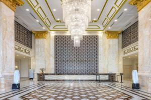 a lobby with a chandelier and a large wall at Meliá Vinpearl Tay Ninh in Tây Ninh