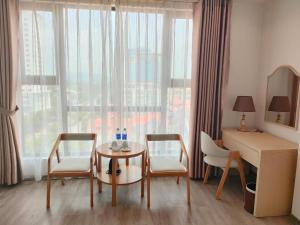 a living room with a table and two chairs and a desk at Smart Hotel in Bắc Ninh