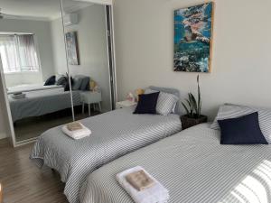 two beds in a bedroom with a mirror at Large bedroom 2 King Single beds Centrally located in Jesmond