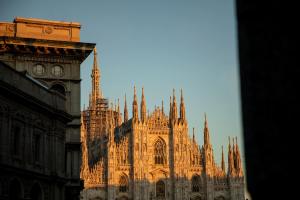 a large cathedral building with a clock tower at Palazzo Cordusio, a Gran Meliá Hotel - The Leading Hotels of the World in Milan