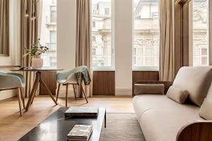 a living room with a couch and a table at Palazzo Cordusio, a Gran Meliá Hotel - The Leading Hotels of the World in Milan