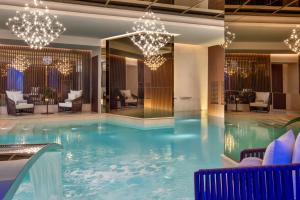 a large swimming pool in a hotel with chandeliers at Palazzo Cordusio, a Gran Meliá Hotel - The Leading Hotels of the World in Milan