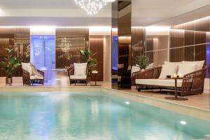 a pool in a hotel with chairs and a table at Palazzo Cordusio, a Gran Meliá Hotel - The Leading Hotels of the World in Milan +128 photos