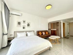 a bedroom with a large white bed and a couch at Riverside Studio - Yuetai Phnom Penh in Phnom Penh +26 photos