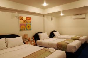 a hotel room with three beds at Ratchaphruek 2007 Hotel in Kang