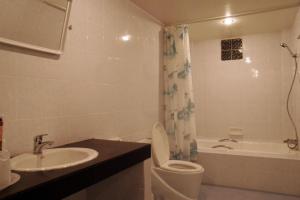 a bathroom with a toilet and a sink at Ratchaphruek 2007 Hotel in Kang +44 photos
