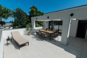 eine Terrasse mit einem Holztisch und Stühlen in der Unterkunft Simedo Boutique Hotel in Mamaia