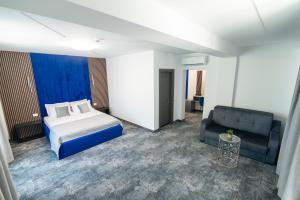 ein Hotelzimmer mit einem Bett und einer Couch in der Unterkunft Simedo Boutique Hotel in Mamaia