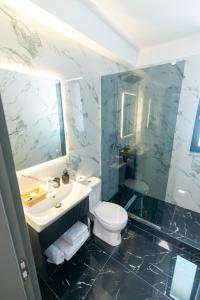 ein Badezimmer mit Toilette, Waschbecken und Spiegel in der Unterkunft Simedo Boutique Hotel in Mamaia + 18 Fotos