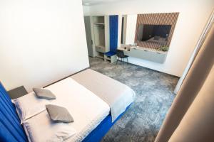 ein kleines Schlafzimmer mit Bett und Fernseher in der Unterkunft Simedo Boutique Hotel in Mamaia