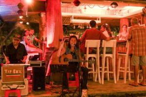 a woman sitting on a stage with a guitar at Seaflower Bungalows in Srithanu +126 photos