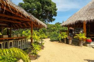 a restaurant with tables and straw umbrellas at Seaflower Bungalows in Srithanu