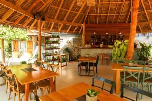 a restaurant with wooden tables and chairs and a bar at Seaflower Bungalows in Srithanu