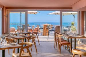 a restaurant with tables and chairs and a view of the ocean at INNSiDE by Meliá Bugibba in St. Paul's Bay