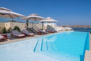 a large swimming pool with chairs and umbrellas at INNSiDE by Meliá Bugibba in St. Paul's Bay
