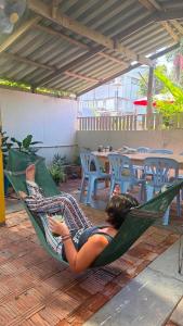 a woman laying in a hammock on a patio at Baan Yuan in Prachuap Khiri Khan