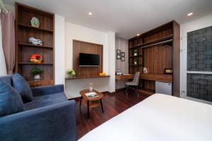 a living room with a blue couch and a desk at TRUNG - The Coffee House in Hanoi