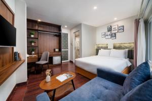 a hotel room with a bed and a couch at TRUNG - The Coffee House in Hanoi