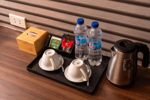 a tray with two bottles of water and a tea kettle at TRUNG - The Coffee House in Hanoi