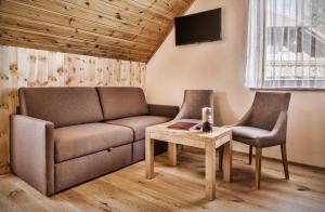 sala de estar con sofá, 2 sillas y mesa en schaus Lüftenegger - Apart-Zirbenpension, en Mauterndorf